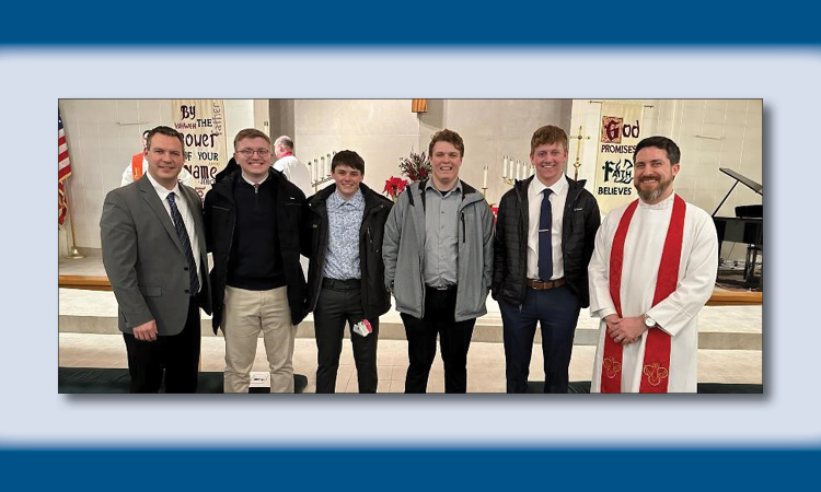 Students in a church with a pastor.