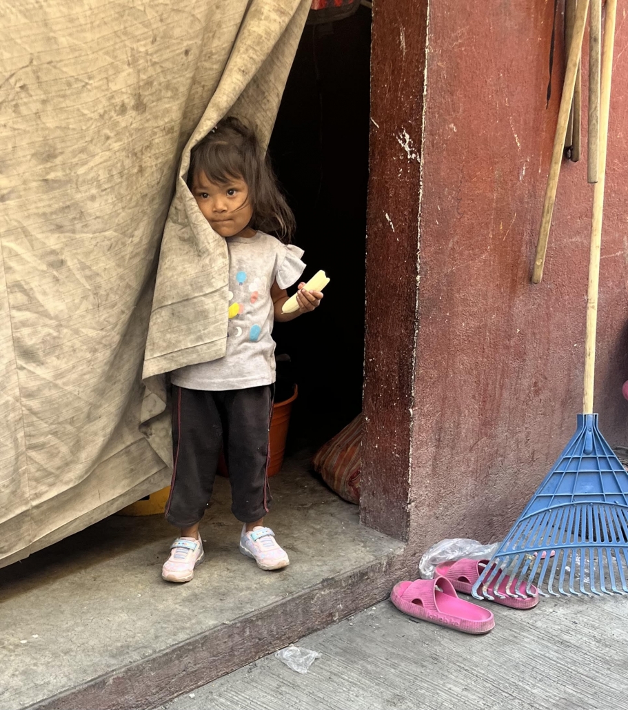 Berenice, small girl standing by curtain
